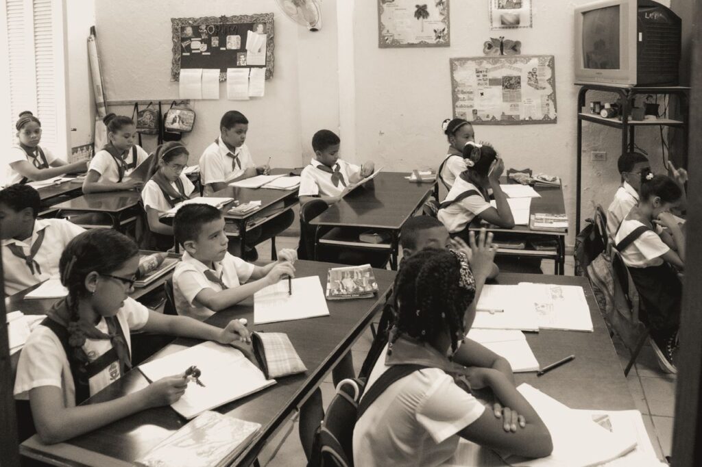 A classroom of attentive school children studying at their desks in uniform.